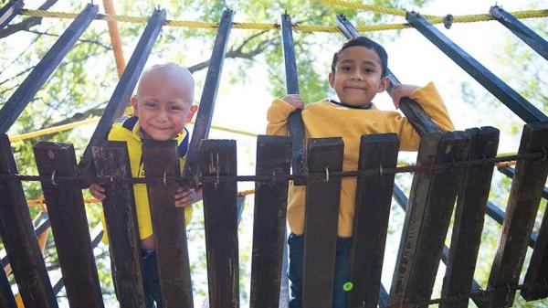 Image of young boys looking down from a wooden bridge